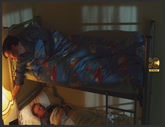 تصویری از دو مرد که هر کدام روی یک طبقه از یک تخت خواب دو طبقه خوابیده اند